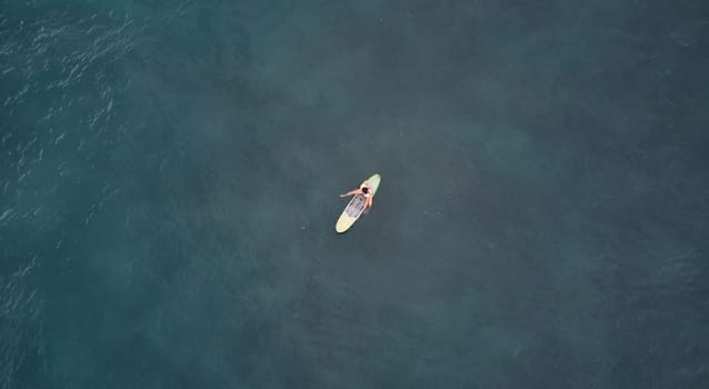 Aerial view of the ocean and surfer girl. Surfing in Midigama. Sri Lanka