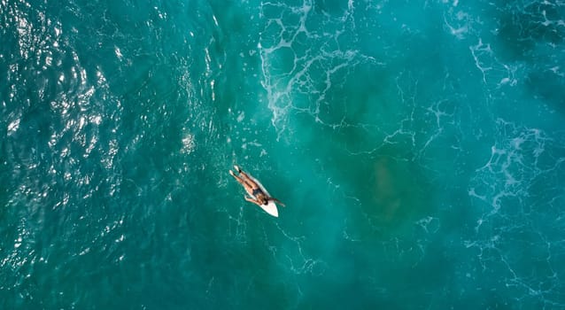 Aerial view of the ocean and surfer girl. Surfing in Midigama. Sri Lanka