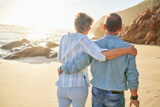 Beach, love and an old couple walking on the sand by the ocean or sea for romance or dating at sunset. Nature, summer or back with a mature woman and man taking a romantic walk together on the coast.