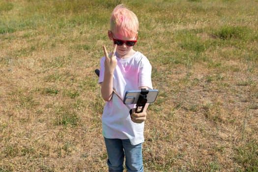 Caucasian Boy Takes Selfie. Photo, Child With Colorful Dye At Birthday Party Or Celebrating Holi Color Festival In Meadow. Cheerful Leisure Time. Horizontal Copy Space.