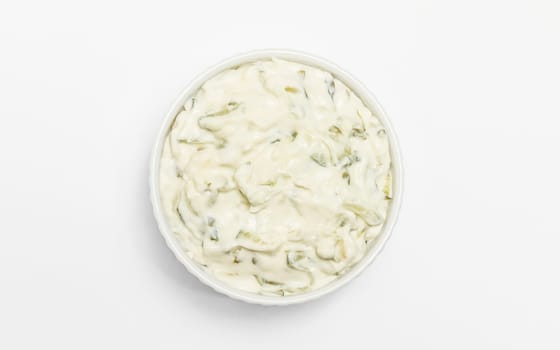 Isolated traditional greek yogurt sauce Tzatziki,dressing in white bowl, made of grated cucumbers, sour cream yogurt,olive oil,garlic,herbs on white background. Close up, flat lay, horizontal