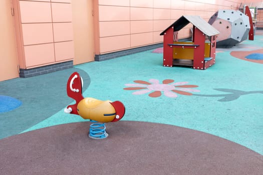 Eco friendly modern colorful children, kids playground, play yard, playset with beautiful soft carpet without children. Swing, wooden house and dodecahedron with climbing walls. Horizontal.