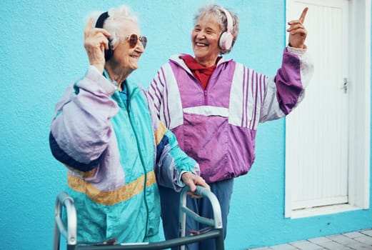 Music, dance and senior women with fashion in city, happy together and streaming on headphones. Retirement, happiness and elderly friends dancing to hip hop audio for fun, freedom and urban style.