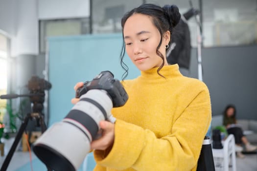 Photography camera, asian woman and digital agency worker review pictures in a studio. Photographer, production process and professional photoshoot with a creative employee checking catalog results.