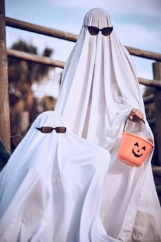 Halloween, friends and ghost costume for fun, festival and celebration while bonding at park, happy and cool. Spooky, dress up and event with people in horror, fantasy and glasses while celebrating.