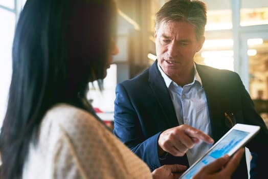 Are you sure these are correct. two businesspeople working together on a digital tablet in an office