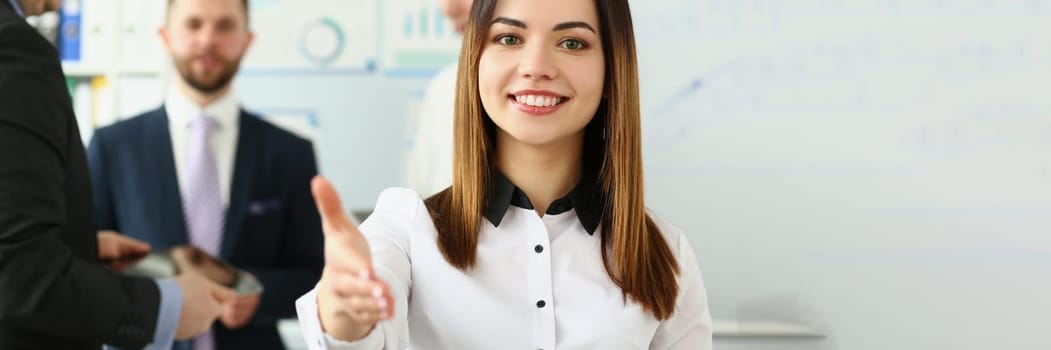 Businesswoman holds out hands for handshake and business team. Handshake gesture and business meeting in office