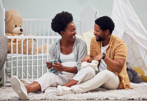 Funny, laundry and black couple getting ready for a baby, folding clothes and preparation in pregnancy. Happy, parents and pregnant woman and man sitting with clothing for child and conversation.