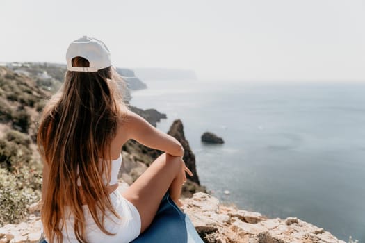 Woman meditating in yoga pose silhouette at the ocean, beach and rock mountains. Motivation and inspirational fit and exercising. Healthy lifestyle outdoors in nature, fitness concept.