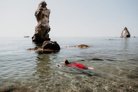 Woman travel sea. Happy tourist taking picture outdoors for memories. Woman traveler looks at the edge of the cliff on the sea bay of mountains, sharing travel adventure journey.