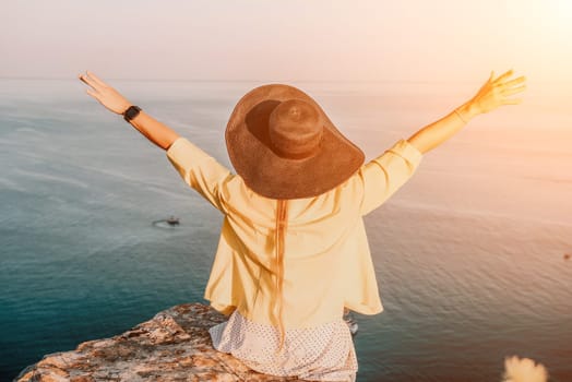 Portrait of happy young woman wearing summer black hat with large brim at beach on sunset. Closeup face of attractive girl with black straw hat. Happy young woman smiling and looking at camera at sea