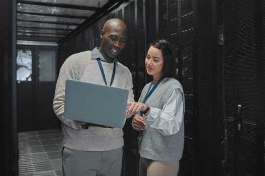 Business, black man and woman with laptop, servers and cyber security for connection, data analytics and conversation. IT specialist, female programmer and employees with device and cloud computing.