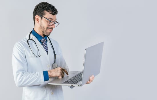 Handsome doctor using laptop isolated. Young doctor in glasses using notebook on isolated background, Smiling doctor standing using laptop isolated