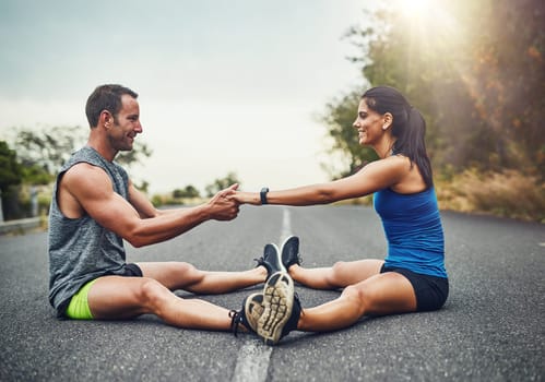 Stretching has become a way of communication for us. a young attractive couple training for a marathon outdoors