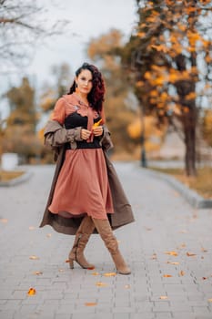 A woman walks outdoors in autumn, enjoys the autumn weather