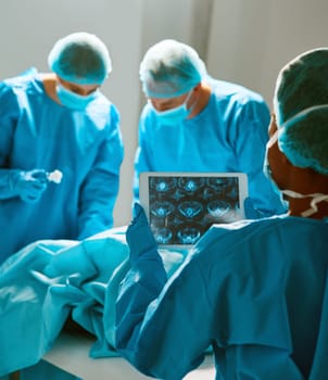 Surgery, operating room and team of doctors with scan for healthcare, teamwork and focus on professional medicine. Medical innovation, technology and surgeon with xray, tablet and staff in hospital