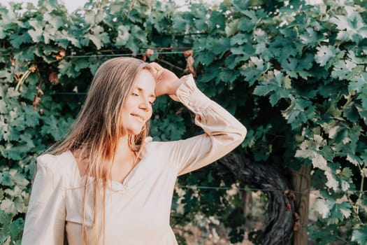 Woman at autumn winery. Portrait of happy woman holding glass of wine and enjoying in vineyard. Elegant young lady in hat toasting with wineglass smiling cheerfully enjoying her stay at vineyard