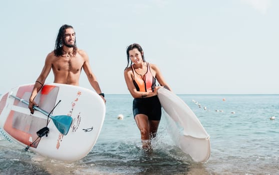 Woman man sea sup. Close up portrait of beautiful young caucasian woman with black hair and freckles looking at camera and smiling. Cute woman portrait in a pink bikini posing on sup board in the sea