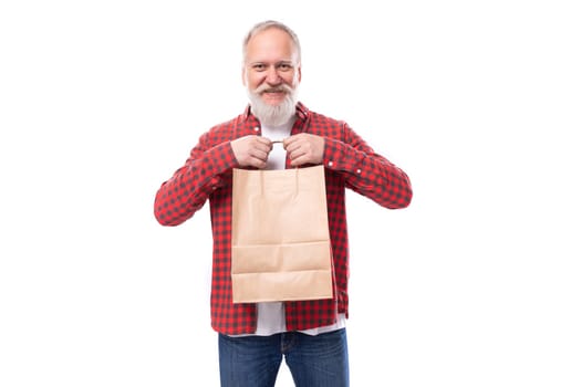 business concept. 60s retired man with white beard and mustache holding shopping bag.