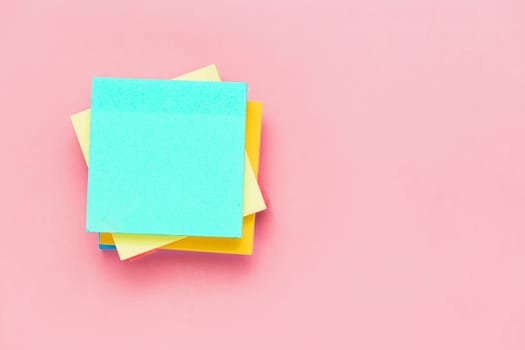 Top view of sticky paper notes on pink background for office and school stationary concept