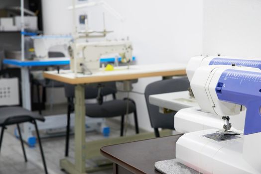 Row of sewing machines in empty atelier studio or tailor shop