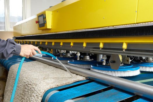 Man worker cleaning carpet on automatic washing machine equipment and dryer in the Laundry room