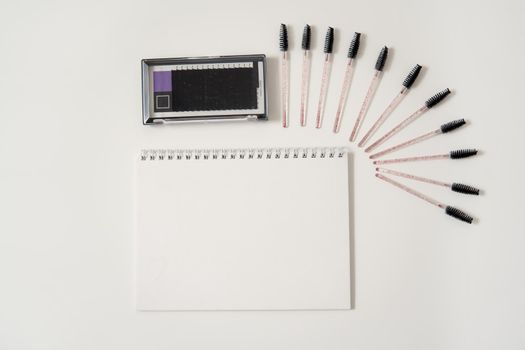 Set of eyelash instruments with a notepad and copyspace