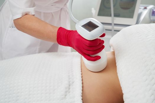 Expert Beautician Doing Abdomen Cavitation Treatment with Ultrasonic Massage Therapy to Reduce Fat