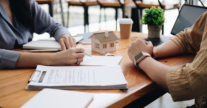 Real estate agent or bank officer describes the loan interest to the customer with home purchase contracts or on office loans and interest rates.