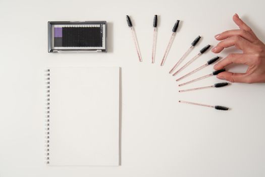 Set of eyelash instruments with a notepad and copyspace