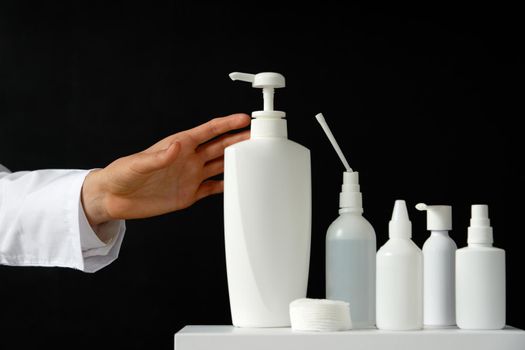 Bottles of hand sanitizers and liquid soap on a black background