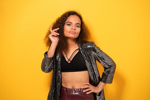 Portrait of a posing beauty ethnic model girl with beautiful hairstyle smile looking at camera wearing shiny black jacket and black top. Horizontal image.