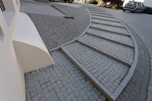 Paving thistle laid evenly in a curve into a spacious staircase leveling the height of the area. Comfortable sidewalk with steps on the stairs.