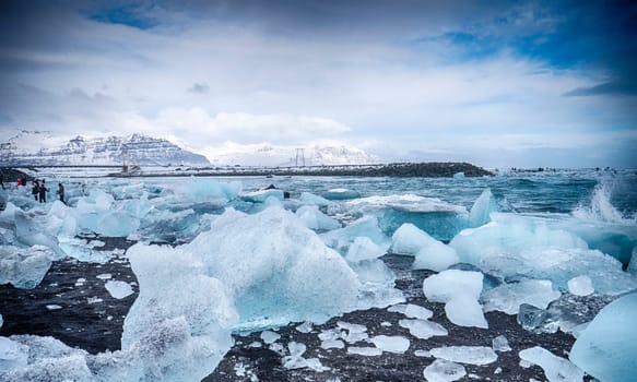 Cold sea water splashing near icy coast in beautiful winter evening in Iceland