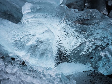 Cold sea water splashing near icy coast in beautiful winter evening in Iceland