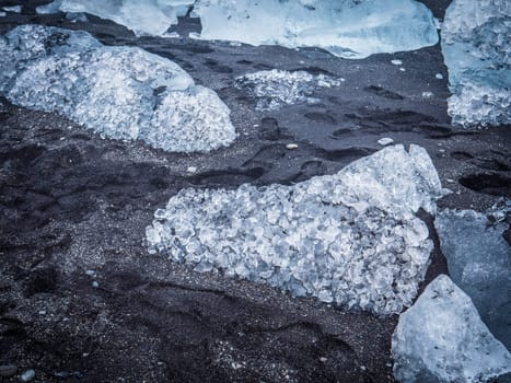 Cold sea water splashing near icy coast in beautiful winter evening in Iceland