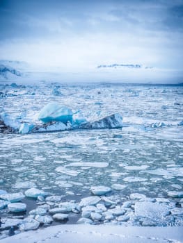 Cold sea water splashing near icy coast in beautiful winter evening in Iceland