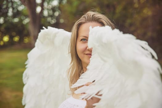 Beautiful woman dressed as an angel in the evening garden.