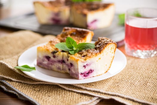 cooked cottage cheese casserole with berry filling in a plate on the table