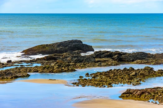 Sand between the rocks and the sea at Prainha beach in Serra Grande on the coast of Bahia