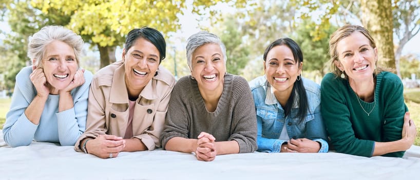 Friends, portrait and senior women on picnic at park for bonding, wellness and relaxing on blanket. Happiness, relax or group of elderly retirement people in interracial friendship in nature together.