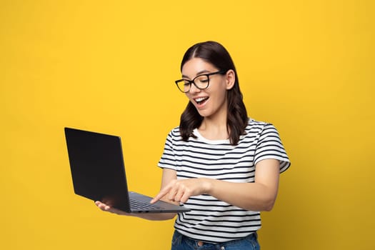 Attractive multi ethnicity female student in glasses happy expression using a laptop.