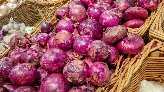 Many heads of red onions in a box