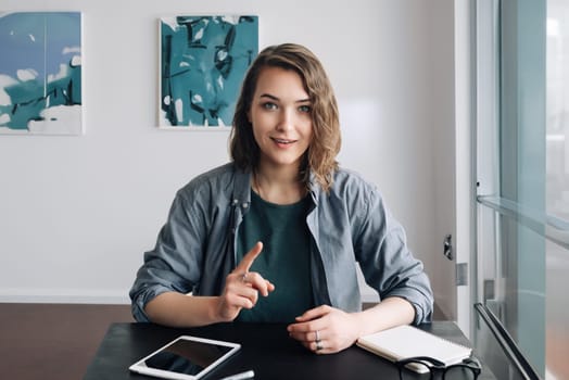 Confident Young Woman Engaging in a Video Conference, Communicating through Web Camera from Office or Home. Life Coaching and Online Business Meeting Concept. Modern Technology