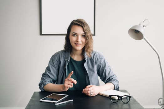 Young Businesswoman Conducting a Video Conference from Office or Home, Engaged and Confident, Demonstrating Life Coaching and Online Business Meeting Concept. Technology Communication in Modern Work.