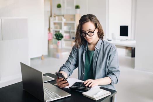 Professional Woman Accountant in Office: Calculating and Managing Finances with Calculator and Computer. Finance and Accounting Concept for Business and Financial Services.