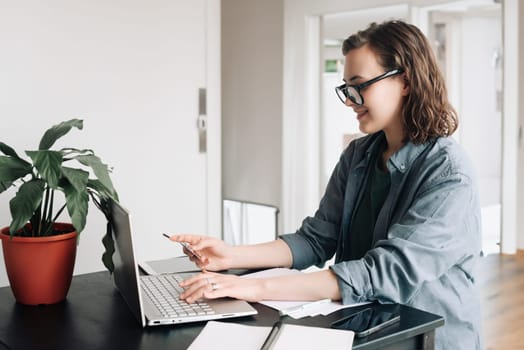 Young woman making online purchase with laptop and credit card. Business, online shopping, e-commerce, internet banking, freelance, and work-from-home concept. Shopping online, digital transactions