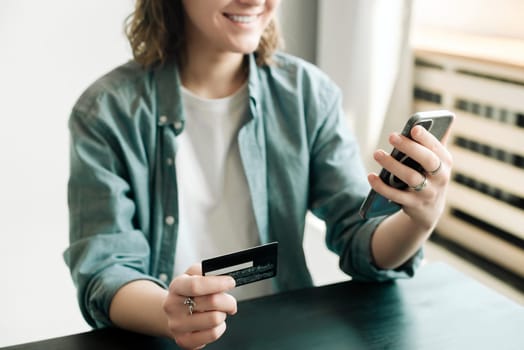Woman holding credit card and using smartphone at home, businesswoman shopping online, e-commerce, internet banking, spending money, working from home concept.