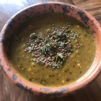 Green lentil soup in a clay bowl on a wooden table (ID: 001451)
