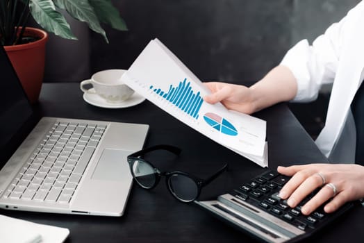 Professional Businesswoman Analyzing Financial Budget and Accounting Data in Office, Calculating Finance Report with Calculator, Strategic Financial Analysis and Budgeting in Action.